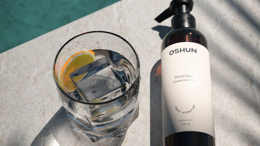 Oshun Electrolyte concentrate by a glass of ice water, poolside